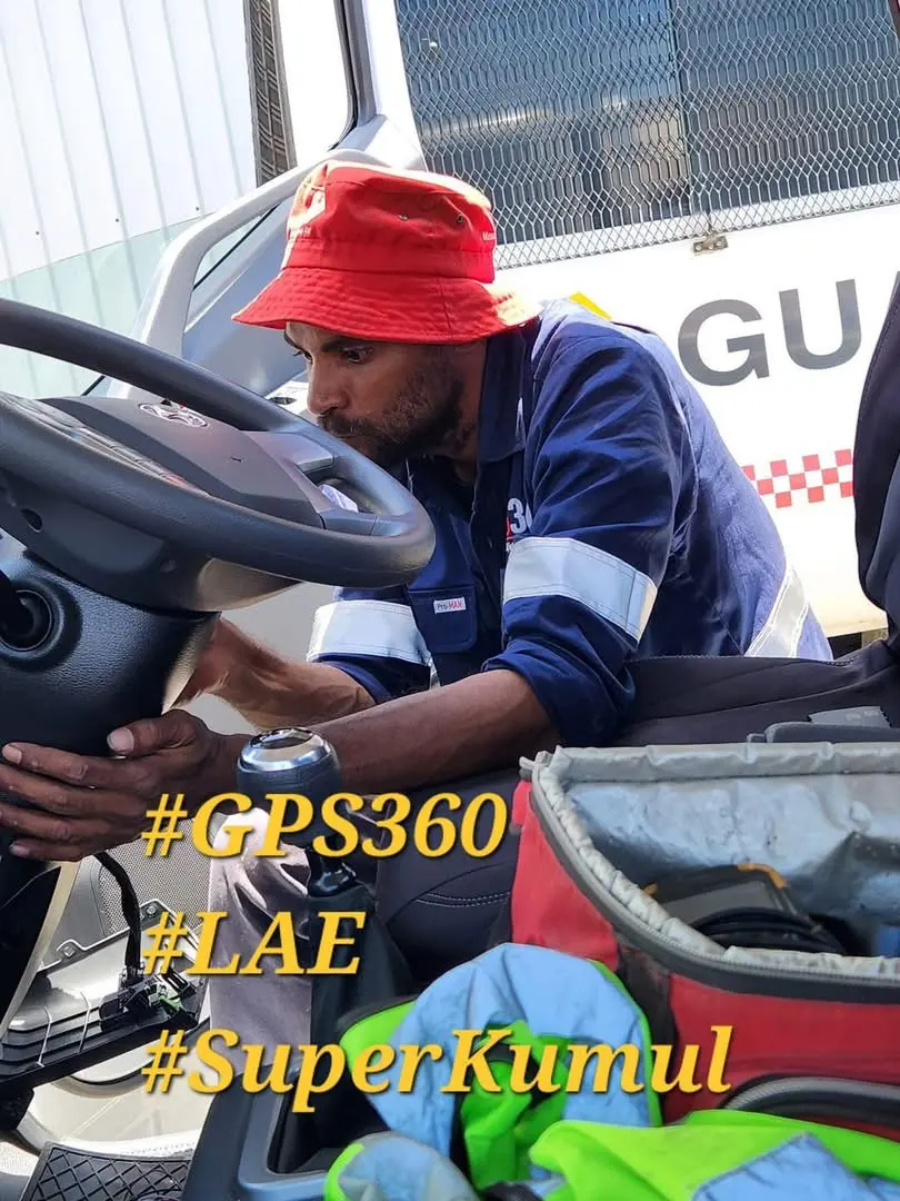 A GPS360 technician installing a tracker in a truck cab in Lae