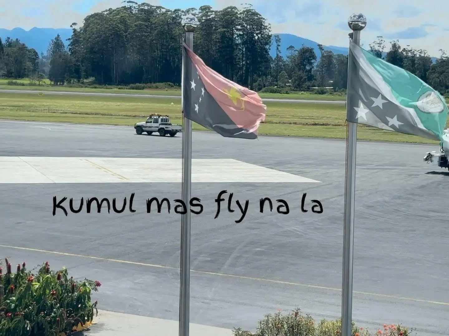 An airside vehicle on the apron at Mount Hagen airport, with the PNG and Western Highlands flags